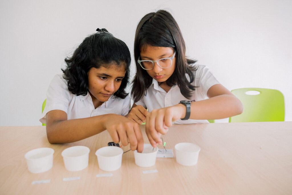 ekya school students stting infront of table